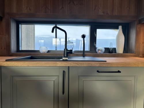 uma cozinha com um lavatório e uma janela em Ski in/ski out i Aurdal - helt ny hytte em Aurdal