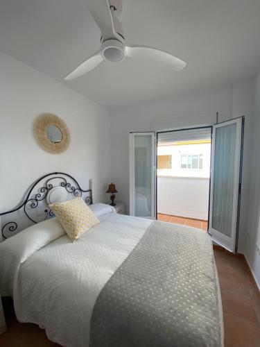 una camera con letto e ventilatore a soffitto di Apartamento ANY a Benaoján