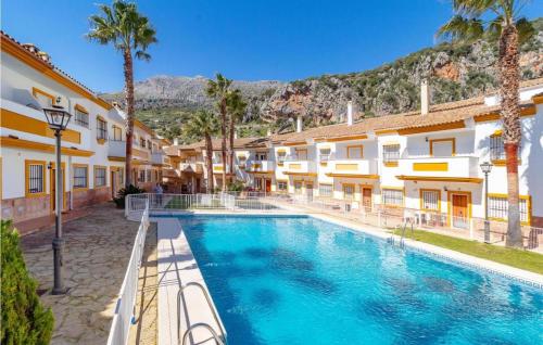a swimming pool in a courtyard of a building with palm trees at Apartamento ANY in Benaoján