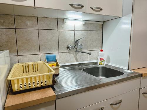 een keuken met een wastafel en een mand op een aanrecht bij Apartman Lokum in Sarajevo