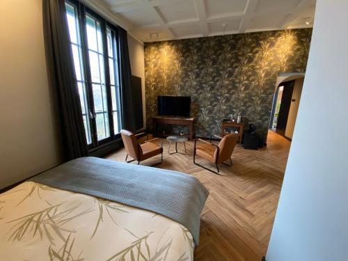 a bedroom with a bed and a table and chairs at Atalanta-Wellness Roermond 'de Wethouder' in Herten