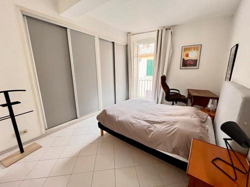 sypialnia z łóżkiem, biurkiem i oknem w obiekcie Appartement spacieux en face du port w Calvi
