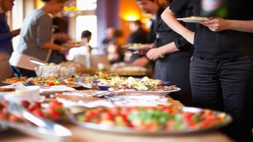 people standing around a table with plates of food at New Osaka Hotel Shinsaibashi in Osaka