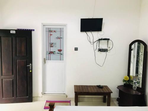 a room with a door and a tv on a wall at Hotel Siyathma polonnaruwa in Polonnaruwa
