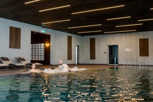 dos personas en el agua en una piscina en Grand Hotel du Cervin - Auberge de jeunesse wellness, en Saint-Luc