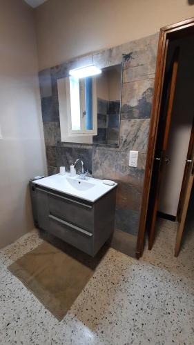 uma casa de banho com um lavatório e um espelho em A l'ombre de l'olivier em Orgon