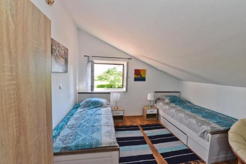 um quarto com 2 camas e uma janela em Holiday Home Taraš em Smilčić