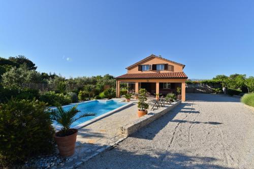 una casa con piscina frente a una casa en Holiday Home Taraš, en Smilčić