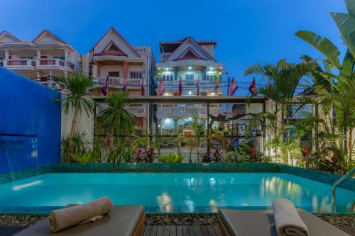 a house with a swimming pool in front of a building at Baahu Villa in Siem Reap