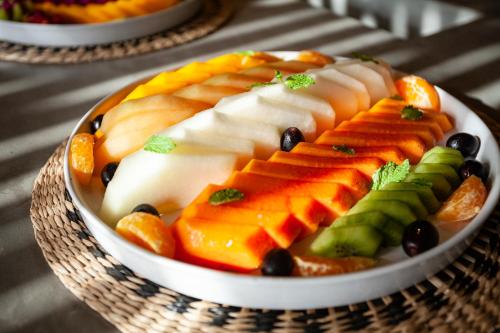 a plate of fruit and vegetables on a table at Hotel VilaVeraTheresa in Fortim