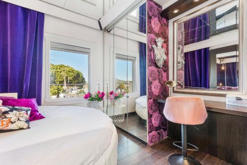 um quarto com cortinas roxas e uma cama com uma cadeira em La vie en rose naturiste - Port Nature em Cap d'Agde