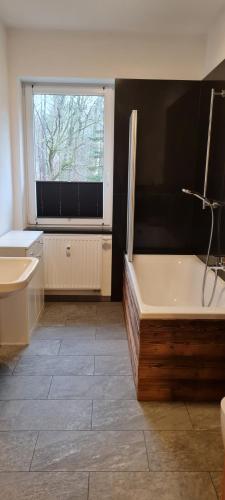ein Bad mit einer Badewanne und einem Fenster in der Unterkunft Gästehaus Hirschstein - Hochwertige Ferienwohnung in sehr ruhiger Lage direkt am Fluss Göltzsch in Reichenbach im Vogtland