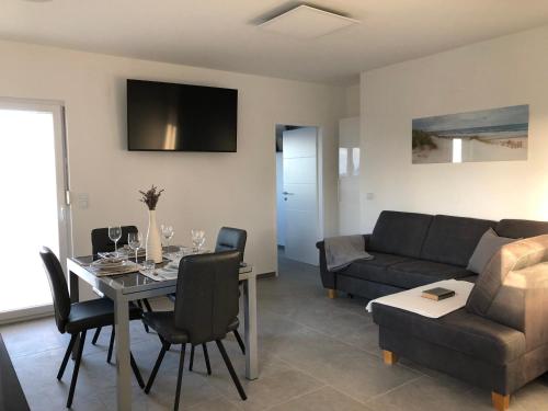 ein Wohnzimmer mit einem Tisch und einem Sofa in der Unterkunft Apartments Villa Prima in Privlaka