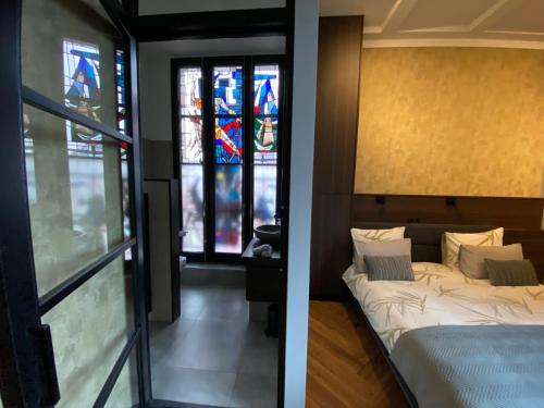 a room with a bed and a stained glass window at Atalanta-Wellness Roermond 'de Wethouder' in Herten