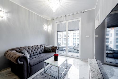 a living room with a couch and a table at Unique Baltic Apartments - Apartament z garażem in Kołobrzeg