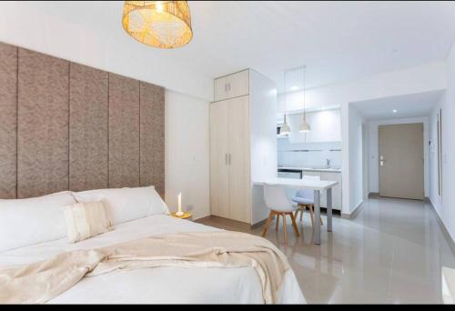 1 dormitorio blanco con 1 cama y comedor en Lujoso Apart en San Telmo-Paseo de la Cisterna-412 en Buenos Aires