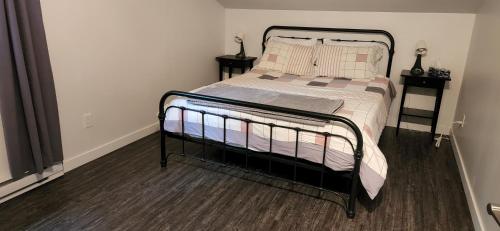 ein Bett in einem kleinen Zimmer mit zwei Nachttischen in der Unterkunft Le Nid doré sur le lac (Golden Nest on the lake) in Val des Monts