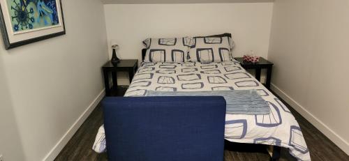 a bedroom with a bed and a blue chair at Le Nid doré sur le lac (Golden Nest on the lake) in Val des Monts