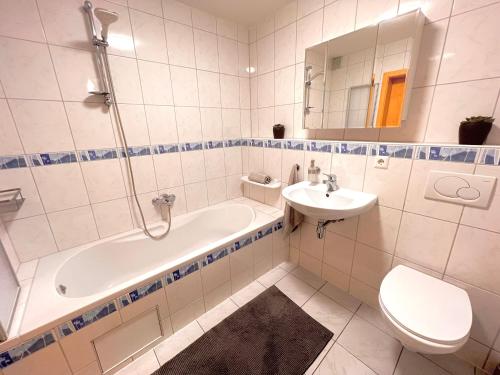 a bathroom with a tub and a sink and a toilet at Black Forest Valley - Nähe Europa Park & Rulantica in Burgheim