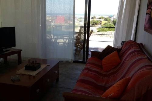sala de estar con sofá y ventana grande en Casa Ambar, vista al mar, Punta del Diablo,Uruguay, en Punta del Diablo