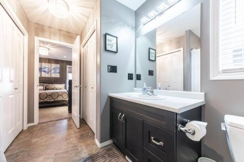 a bathroom with a sink and a toilet and a bed at Modern House Fenced Back Yard BBQ Garage in Lloydminster