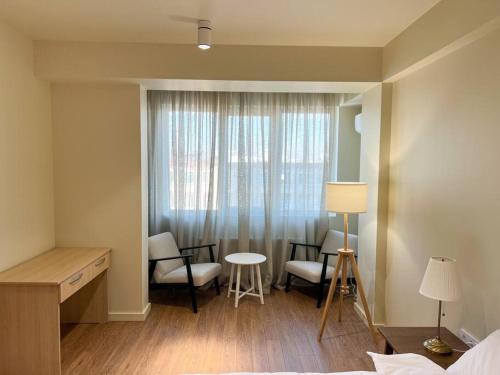 Pokój z łóżkiem, krzesłami i oknem w obiekcie 2 bedroom on Ismail corner Stefan cel Mare, new apartment, Chisinau center! w Kiszyniowie