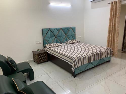 1 dormitorio con 1 cama y 1 silla en Staywell360, en Chandīgarh