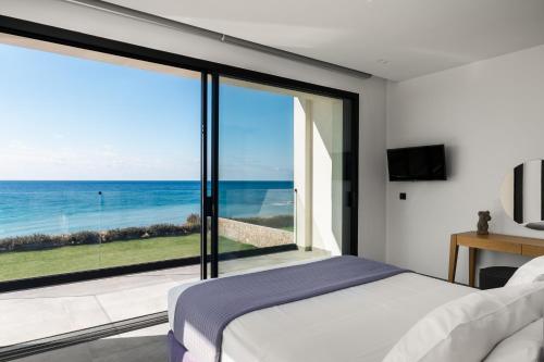 a bedroom with a bed and a view of the ocean at Villa Afroditi, Corfu in Halikounas