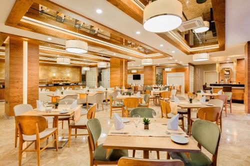 a restaurant with wooden tables and chairs at Kahya Hotel Ankara in Ankara