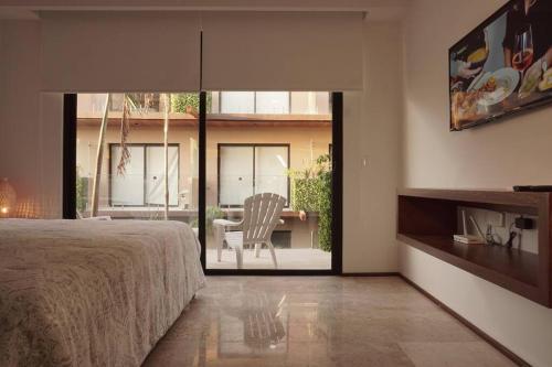 Un dormitorio con una cama y una mesa con una silla. en Noah luxury loft in Downtown, en Tulum