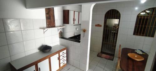 a small bathroom with a sink and a mirror at POUSADA VENTO NORTE CAMA & CAFÉ SUÍTES INDIVIDUAIs in João Pessoa