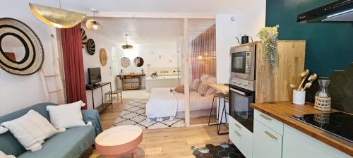 a living room with a blue couch and a kitchen at Les Gîtes du Goelo in Plouha