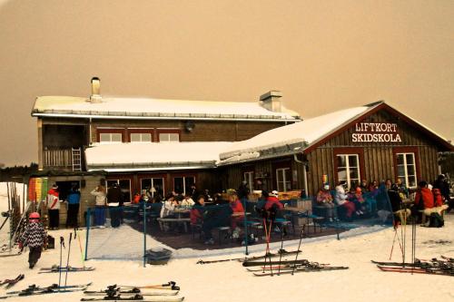 a ski lodge with a group of people in front of it at Parkstigens Fjällby - Kåvan in Funäsdalen