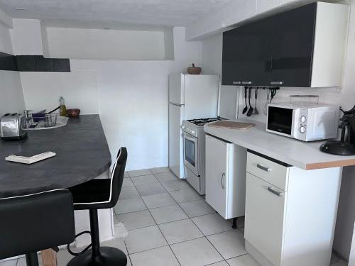 a kitchen with white appliances and a counter top at Bas De Maison in Olivese