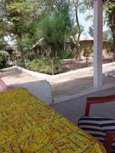 une table avec un tissu de table jaune sur une terrasse dans l'établissement Abenebolong, à Abémé