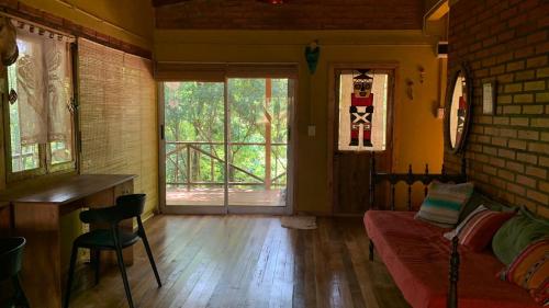 Habitación con sofá, mesa y ventana en Casa Monte en Puerto Iguazú
