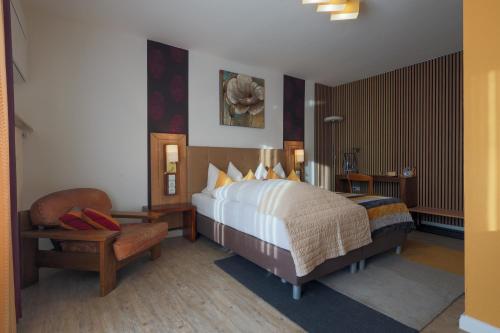 Franconia City Hotel في نورنبرغ: غرفه فندقيه بسرير وكرسي