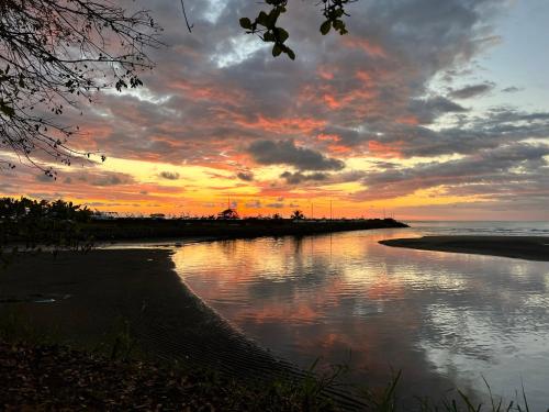 una puesta de sol sobre una playa con un cuerpo de agua en Vista Bosque 1, en Quepos