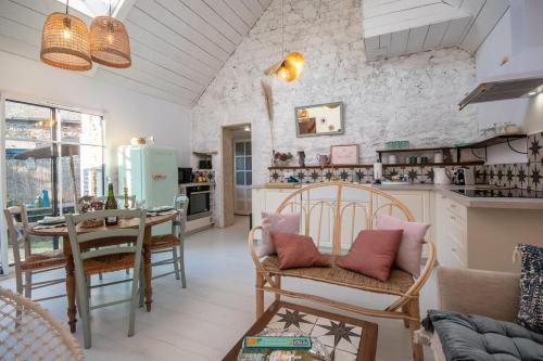 un soggiorno con tavolo e sedie e una cucina di Les Gîtes du Goelo a Plouha