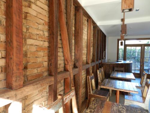 a room with a brick wall and wooden tables and chairs at Aroma Verde Hotel in Valdivia