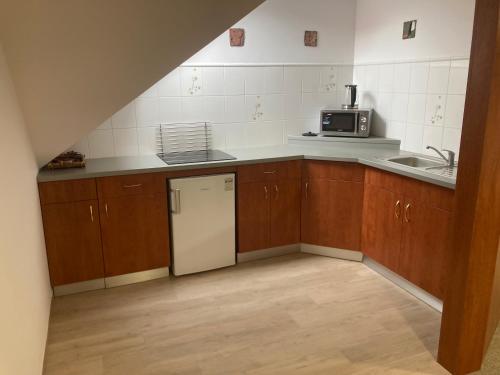 a kitchen with wooden cabinets and a white refrigerator at Světlá nad Sázavou dům s výhledem in Světlá nad Sázavou