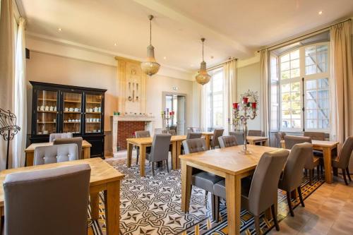 een eetkamer met houten tafels en stoelen bij Chateau de Didonne in Sémussac