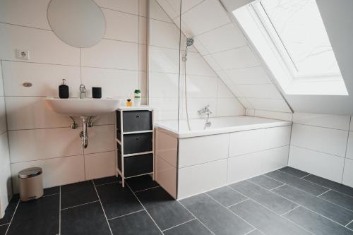 uma casa de banho com um lavatório e uma banheira em Working Apartment - 8 single beds - 5 Schlafzimmer em Mönchengladbach