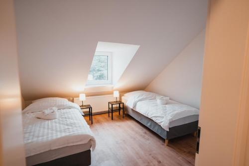 a attic bedroom with two beds and a window at Working Apartment - 8 single beds - 5 Schlafzimmer in Mönchengladbach