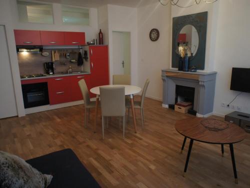 uma sala de estar com mesa e cadeiras e uma cozinha em AppartsHotels'De Ville em Bourg-lès-Valence