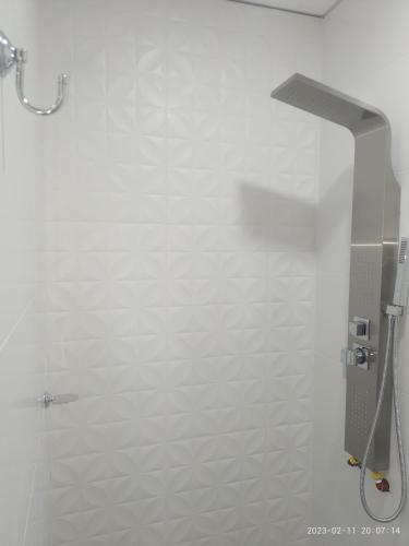 a bathroom with a shower and a white wall at La Cabaña de Eco Verde in San Rafael