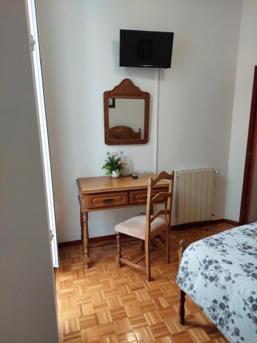 a bedroom with a desk with a mirror and a chair at Residencial Real - Antiga Rosas in Vila Real