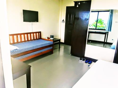 a bedroom with a bed and a television and shoes at Adayo Cove Resort in Siquijor