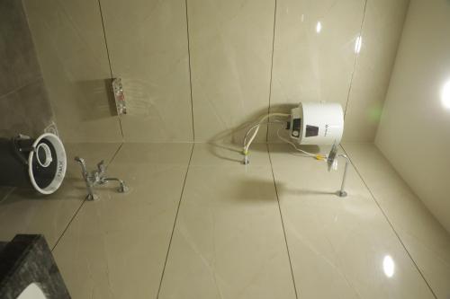 uma cabina de duche com um dispensador de papel higiénico na casa de banho em Hotel Panch em Kalol