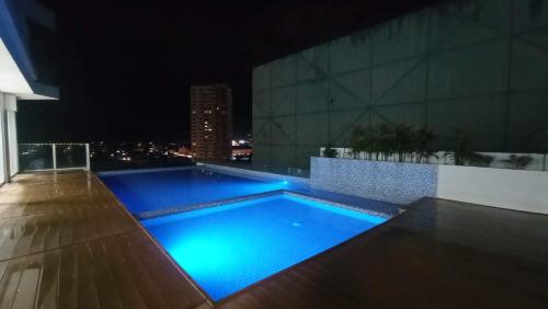 達沃市的住宿－Condo Saga Davao City，一座游泳池,在晚上在一座建筑的顶部